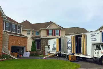 White moving trucks waiting in front of the client's residence 