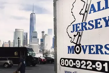 A white truck from All Jersey Moving and Storage is standing in the parking 