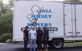 People standing in front of All Jersey Movers Van