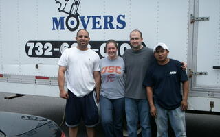 The client is standing with a couple of men from All Jersey Movers