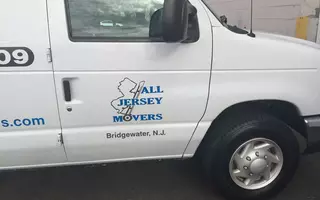 The righthand side door of the White moving truck shows the logo of All Jersey Movers