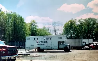 A white moving truck from All Jersey Movers is standing in the parking